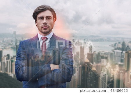 Succesful and rich. Close-up portrait of attractive man in suit keeping his arms crossed while 48486623