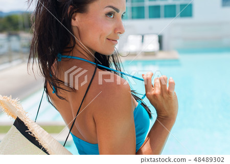 Happy brunette suntanned woman in blue swimsuit Happy brunette suntanned woman in blue swimsuit 48489302