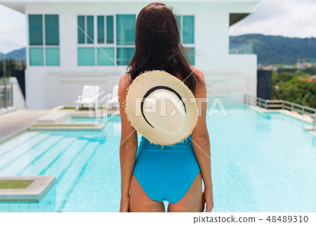 Young bright brunette woman blue swimsuit relaxing 48489310