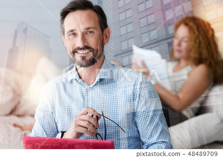Clever handsome man holding his glasses and smiling 48489709
