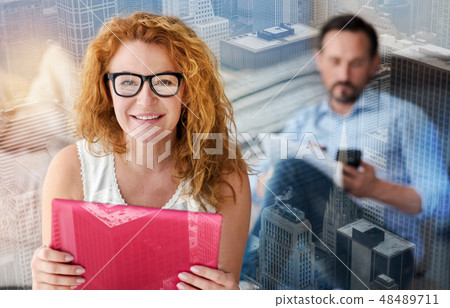 Lovely smiling woman enjoying her new convenient gadget 48489711