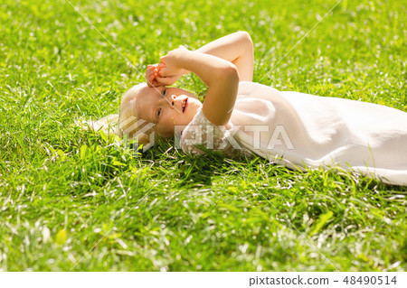 Pretty small girl looking at the sky Pretty small girl looking at the sky 48490514