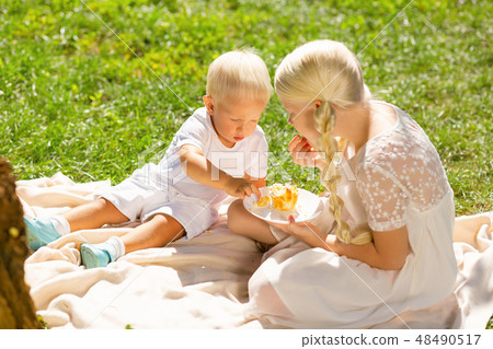 Calm children eating sweets in the park Calm children eating sweets in the park 48490517