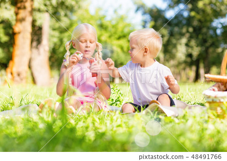 Pleasant children playing together in the park Pleasant children playing together in the park 48491766