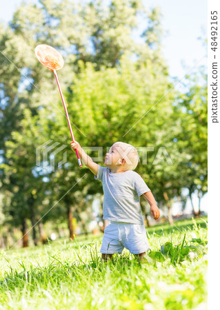 Happy little boy catching butterflies in the garden Happy little boy catching butterflies in the garden 48492165