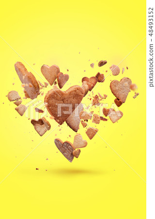 Card with flying crisp biscuit in the shape heart 48493152