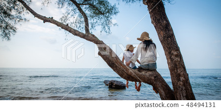 在海灘的母親和女兒上升的樹 48494131