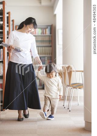 Parent and child walking in the library 48494303