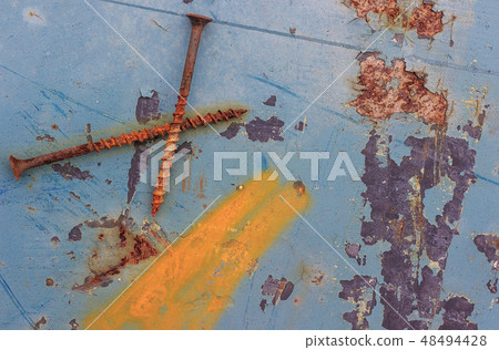 Old nails lie on the blue rusty surface. 48494428