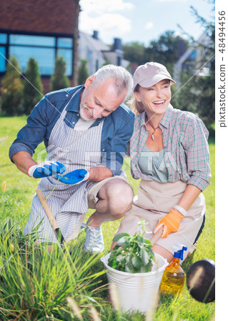 Happy loving couple taking care of their garden bed outside the house Happy loving couple taking care of their garden bed outside the house 48494456