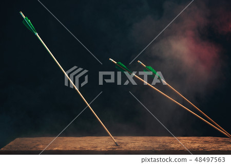 Three wood arrow on a wooden table. Three wood arrow on a wooden table. 48497563