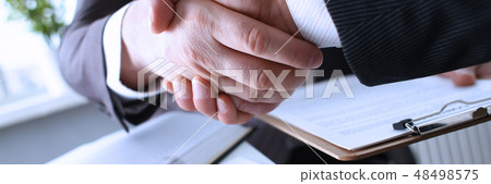 Man in suit shake hand as hello in office Man in suit shake hand as hello in office 48498575