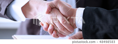 Man in suit shake hand as hello in office Man in suit shake hand as hello in office 48498583