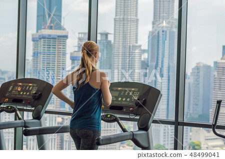 sport, fitness, lifestyle, technology and people concept - woman exercising on treadmill in gym 48499041