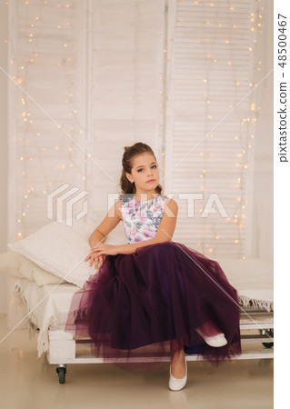 Beautiful girl in a purple dress and flower blouse posing for a photographer 48500467