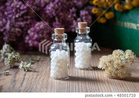 Bottles of homeopathic pills with dried herbs 48501710