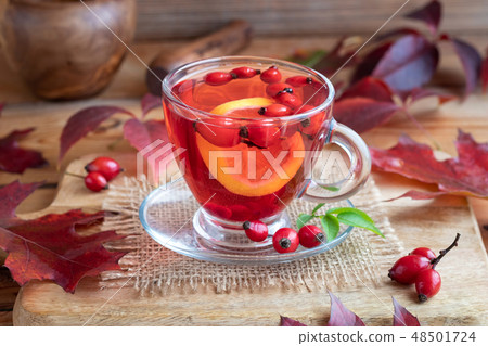 A cup of rose hip tea with fresh rose hips A cup of rose hip tea with fresh rose hips 48501724