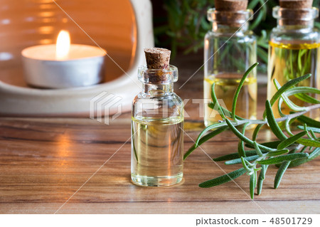 A bottle of rosemary essential oil with rosemary A bottle of rosemary essential oil with rosemary 48501729