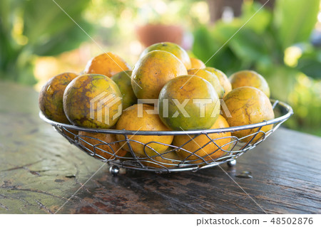 Tangerine in a silver metal basket on the old wood Tangerine in a silver metal basket on the old wood 48502876