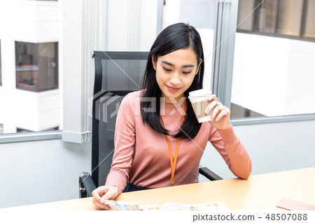 觀看雜誌飲用的咖啡的婦女 觀看雜誌飲用的咖啡的婦女 48507088