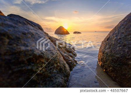 Sea sunset rocks beach on blue sky background. Beauty evening sunrise. Blue background. Sea sunset rocks beach on blue sky background. Beauty evening sunrise. Blue background. 48507667