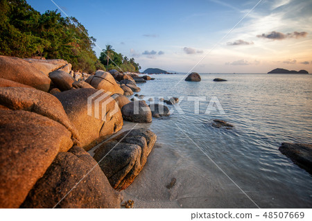 Sea sunset rocks beach on blue sky background. Beauty evening sunrise. Blue background. Sea sunset rocks beach on blue sky background. Beauty evening sunrise. Blue background. 48507669