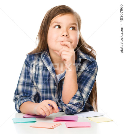 Girl is writing on color stickers using pen Girl is writing on color stickers using pen 48507960