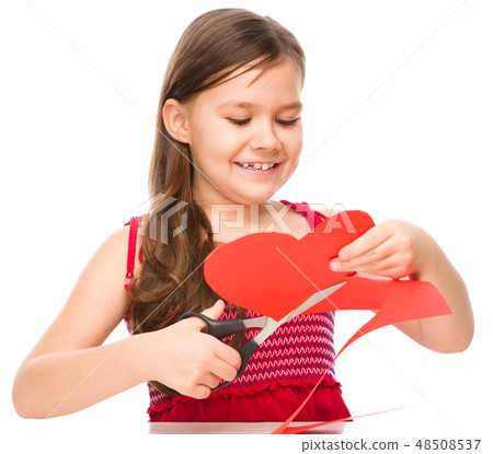 Portrait of a little girl cutting out red heart Portrait of a little girl cutting out red heart 48508537