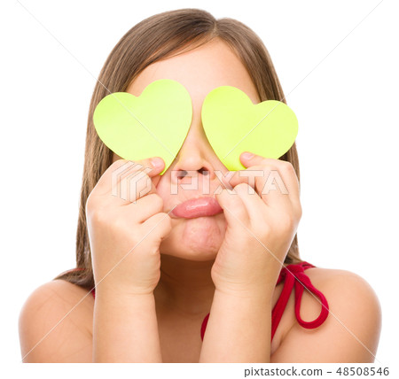 Little girl is holding hearts over her eyes Little girl is holding hearts over her eyes 48508546