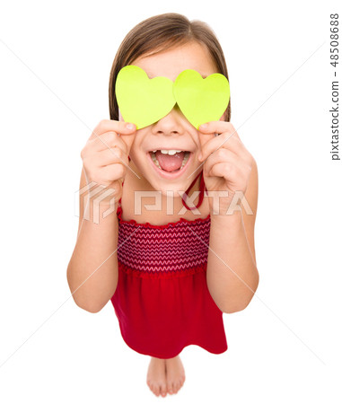 Little girl is holding hearts over her eyes 48508688