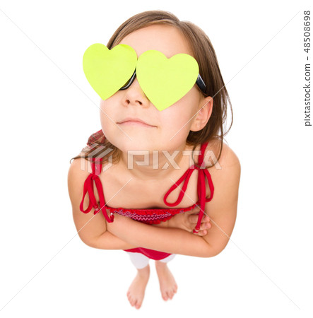 Little girl is holding hearts over her eyes Little girl is holding hearts over her eyes 48508698