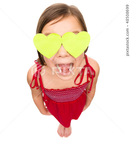 Little girl is holding hearts over her eyes Little girl is holding hearts over her eyes 48508699