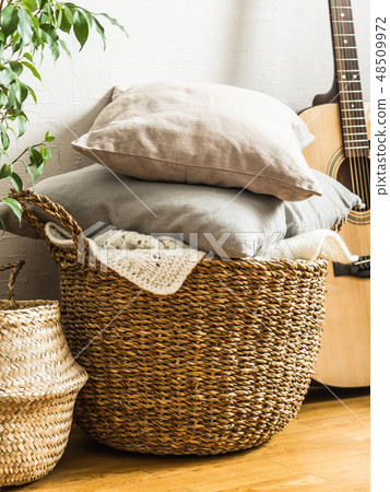 Wicker basket with  gray cushions, houseplant and  48509972