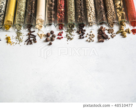 Various dry spices in glass tubes and spilled 48510477