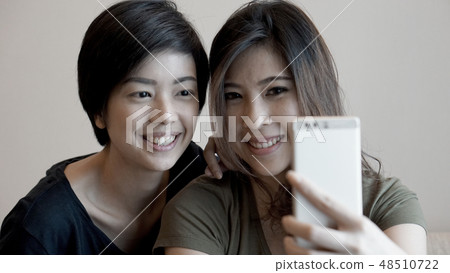 Two Asian woman taking photo, selfie cell phone 48510722