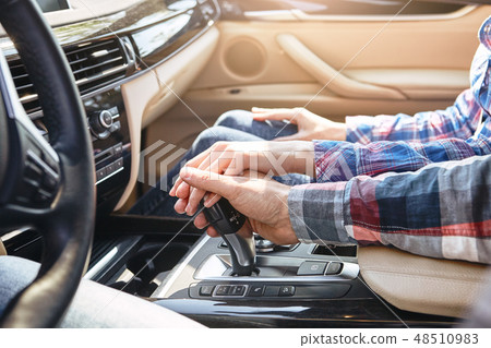 A lifetime of adventures. Close up of young couple holding hands together in car. Family road trip 48510983