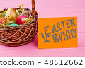 Woven basket filled with Easter eggs. 48512662