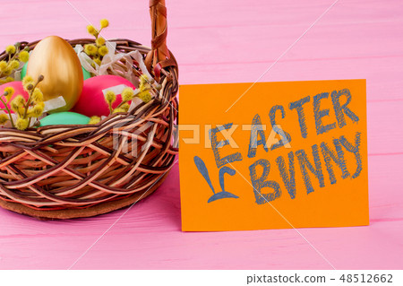 Woven basket filled with Easter eggs. Woven basket filled with Easter eggs. 48512662