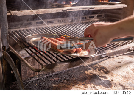 food, delicious and meat concept - roasting horse meat sausages grilled. 48513540