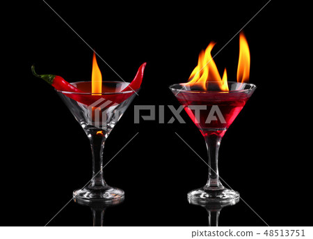 Hot chili pepper in a martini glass with a fire Hot chili pepper in a martini glass with a fire 48513751