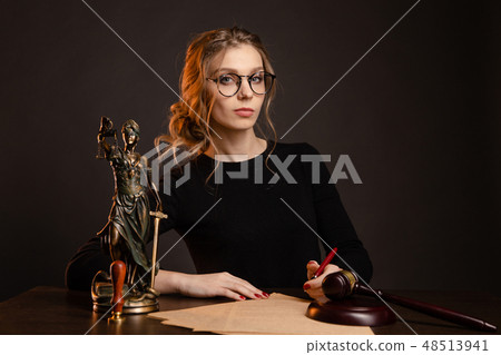 Pretty young woman in a glasses and in a black dress sitting and wrighting importaint document Pretty young woman in a glasses and in a black dress sitting and wrighting importaint document 48513941