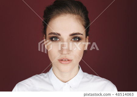 Closeup picture of handsome young woman posing in a studio isolated over the dark pink background. 48514063