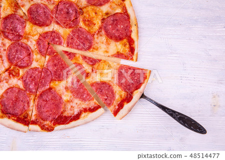 The pizza cut on pieces with cheese The pizza cut on pieces with cheese 48514477