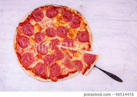 The smoked products pizza cut by pieces with tomat 48514478