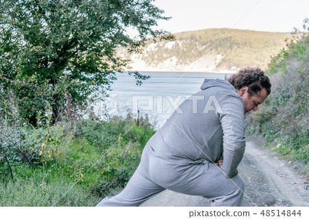 Fat man doing warm-up in nature 48514844