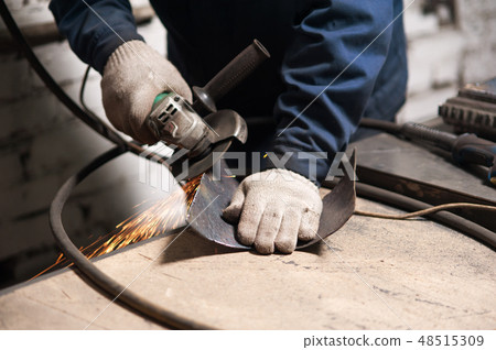 Close up of blacksmith grindering a metal plate Close up of blacksmith grindering a metal plate 48515309