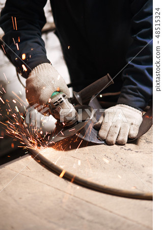 Close up of blacksmith grindering a metal plate Close up of blacksmith grindering a metal plate 48515324