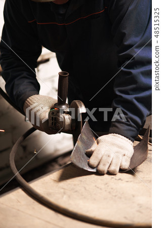 Close up of blacksmith grindering a metal plate Close up of blacksmith grindering a metal plate 48515325