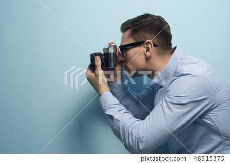 Young male photographer holding a new camera Young male photographer holding a new camera 48515375