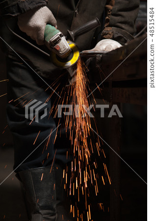 Blacksmith Polishes Metal Products Using A Grinding Machine Blacksmith Polishes Metal Products Using A Grinding Machine 48515484